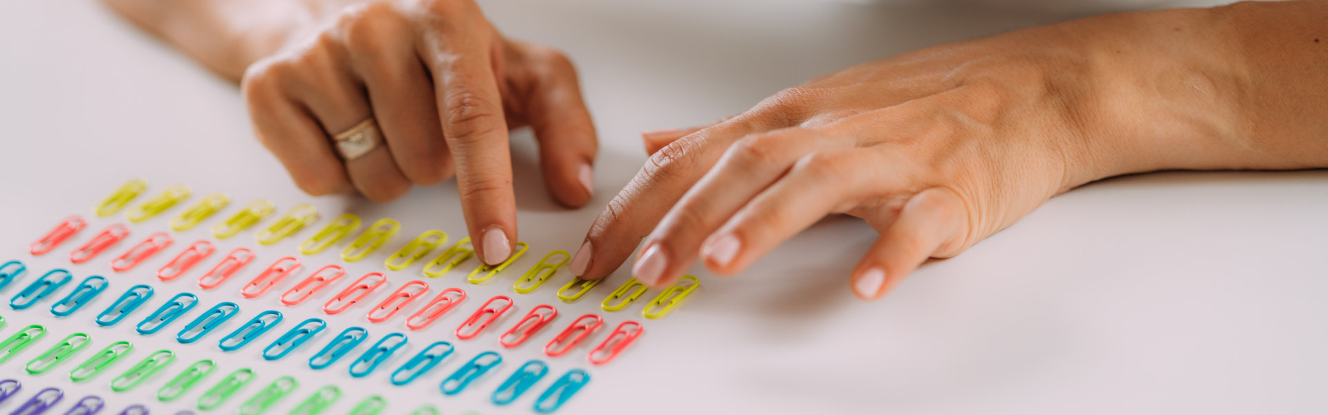 a person arranging paper clips in a row.